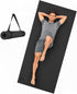 Black extra-long wide yoga mat with a man lying on it, alongside the mat rolled and secured with a carrying strap.
