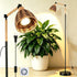 adjustable floor grow light beside large indoor plant