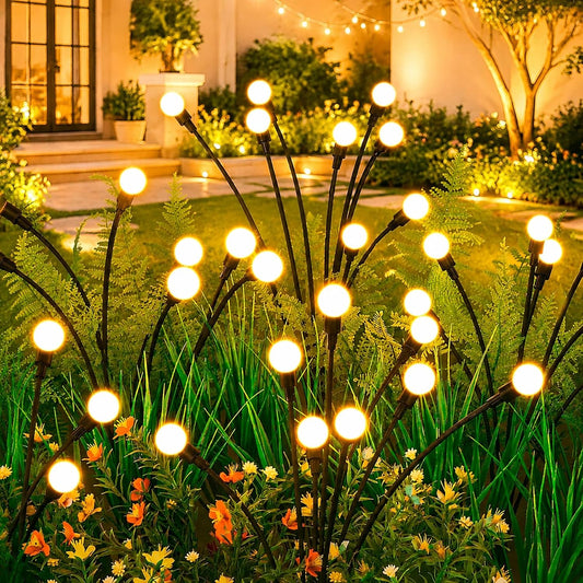 Four solar firefly garden lights glowing in backyard